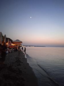 a group of people walking on the beach at sunset at A Casa D'Irene in Perea +9 photos