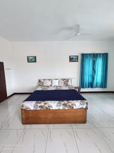 a bed in a white room with blue curtains at Beach wave villa in Tirupporūr