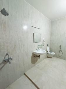 a bathroom with a sink and a toilet at Beach wave villa in Tirupporūr