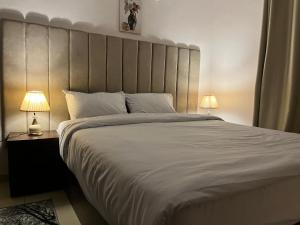 una camera da letto con un letto grande con due lampade di King Badr pyramids a Il Cairo