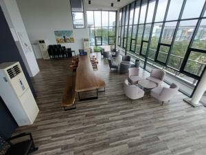 a large lobby with chairs and tables and windows at Mupify Homestay Gala City Gala Residences A4 in Kuching