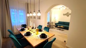 a dining room with a table and green chairs at Homely Stay - Urban Oasis Apartments in Moosburg