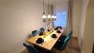 a dining room with a wooden table and blue chairs at Homely Stay - Urban Oasis Apartments in Moosburg