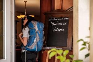 een persoon met een rugzak die in een deuropening staat bij Hotel-Restaurant Dimmer in Wallendorf pont