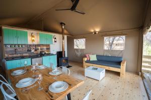 a living room with a wooden table and a couch at AfriCamps Waterberg in Vaalwater