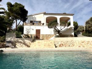 uma casa com piscina em frente a uma casa em Casa Inés em Cala Murada
