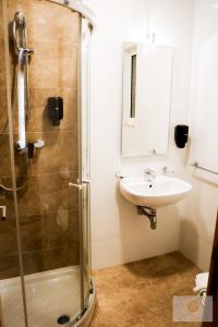 een badkamer met een glazen douche en een wastafel bij Ta' Tereża Seafront Apartments in St Julian's