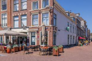 una calle con mesas y sillas frente a un edificio en LOT Hotel en Leiden