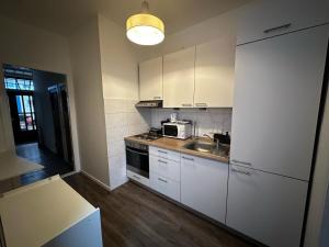 a kitchen with white cabinets and a sink and a microwave at Royal Apartments Bremen - Ferienwohnungen & Fahrradverleih in Bremen