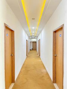 un couloir vide dans un immeuble de bureaux doté d'un plafond jaune dans l'établissement Usha Residency, à Bhuj