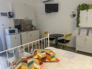 a bedroom with a bed and a kitchen with a table at Catania Centro Storico in Catania
