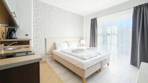 sypialnia z łóżkiem oraz kuchnia ze zlewem w obiekcie Apartamenty Sun & Snow Promenada I w Świnoujściu