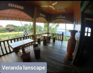 BanlungにあるRatanakiri Lakeside Homestay & Toursのウッドフロアのパビリオン(ベンチ、テーブル付)