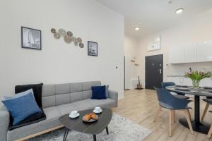 ein Wohnzimmer mit einem Sofa und einem Tisch in der Unterkunft Unique Apartment with Balcony in Swinoujscie by Rent like home in Świnoujście