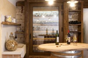 einen Weinkeller mit einem Tisch und 2 Flaschen Wein in der Unterkunft Villa Santa Domenica near Poreč with play room, beautiful tavern & garden in Labinci