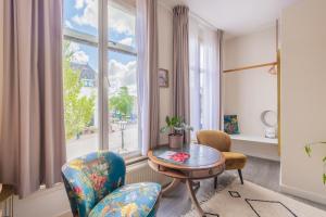 a living room with a table and chairs and a window at LOT Hotel in Leiden