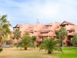 een roze gebouw met palmbomen ervoor bij Sun and Golf Apartment by Rentalole in Torre-Pacheco