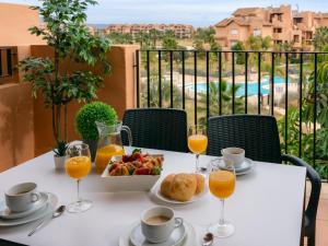 een tafel met een bord eten en een glas sinaasappelsap bij Sun and Golf Apartment by Rentalole in Torre-Pacheco