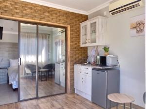 a kitchen with white cabinets and a dining room at The Cape Lodge in Upington