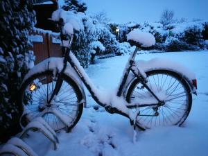 una bicicleta estacionada en un patio cubierto de nieve en CRYSTAL HOTEL, en Claye-Souilly