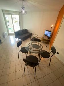 sala de estar con sillas, sofá y TV en Terracotta - Cosi - WIFI - Parking - Terrasse, en Saint-Orens-de-Gameville