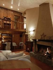 a living room with a fireplace and a couch at Baita Le Pozze in Abetone