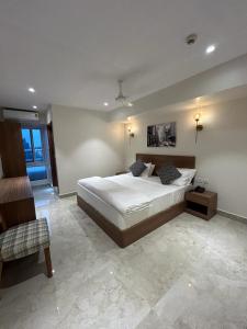a large bedroom with a bed and a chair at Swanotel Gachibowli in Gachibowli