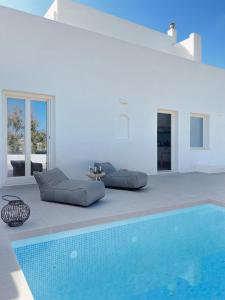 una sala de estar con piscina y una casa en thEros - apartment 1, en Parikia