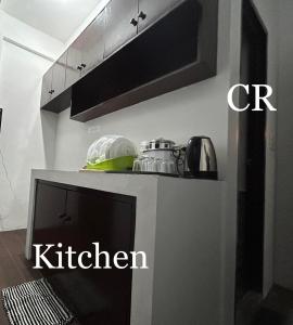 eine Küche mit Mikrowelle und ein Küchenzeichen in der Unterkunft Private room with AC and fan at EKG House Rental in Manila
