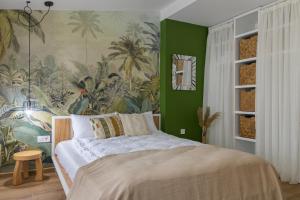 1 dormitorio con 1 cama grande y papel pintado tropical en Къщата en Isperikh