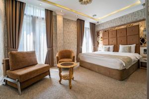 une chambre d'hôtel avec un lit et une chaise dans l'établissement Hotel Aqua Liberty, à Tbilissi