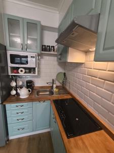a small kitchen with a sink and a microwave at Miętówka in Żywiec +7 photos