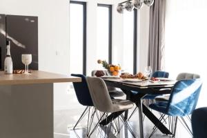 a dining room with a table with blue chairs at Apartmani Carmen in Bibinje
