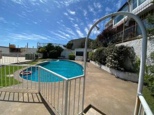 une porte métallique menant à une piscine dans l'établissement Moderno Depto Estudio frente a Playa Amarilla, à Concón