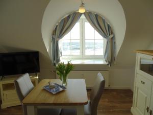 ein Esszimmer mit einem Tisch und einem Fenster in der Unterkunft Im Haus Deichgraf in Dahme