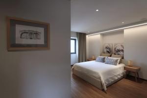 a bedroom with a bed and a picture on the wall at Quinta de Travanca - Casa do Páteo, Baião, Douro in Baião