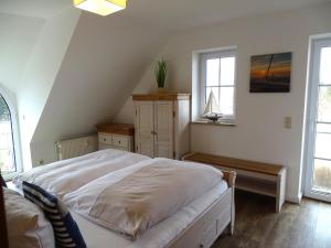 Schlafzimmer mit einem Bett, einem Tisch und Fenstern in der Unterkunft Im Haus Deichgraf in Dahme