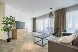 ein Wohnzimmer mit einem Sofa und einem TV in der Unterkunft Brand new luxury penthouse in Gzira just a few meters away from the promenade and amenities in Gżira