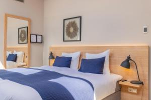 a bedroom with a blue and white bed with blue pillows at City Hotel Rembrandt in Leiden