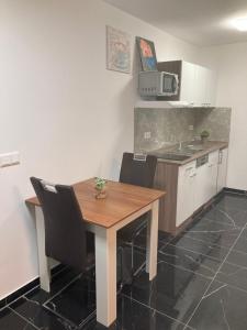 cocina con mesa de madera y algunas sillas en Sofa Apartment, en Seeheim-Jugenheim