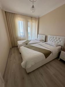 sypialnia z 2 łóżkami i dużym oknem w obiekcie green city yalıncak w mieście Cimenli