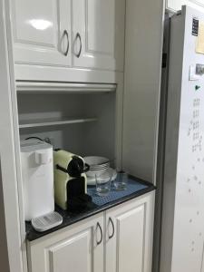 encimera de cocina con electrodomésticos en la parte superior de una nevera en Castle Hill的独立房间, en Castle Hill