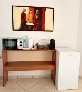 a microwave and a refrigerator in a room at Il rifugio dello scultore in Niscemi