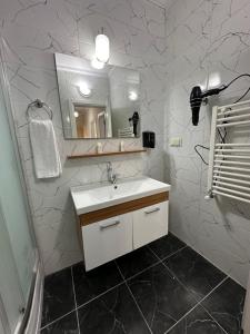 a white bathroom with a sink and a mirror at green city yalıncak in Cimenli