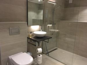 La salle de bains est pourvue d'un lavabo, d'une douche et de toilettes. dans l'établissement Risør Hotel, à Risør