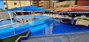 a swimming pool with blue water and umbrellas at Parque das Águas Quentes in Caldas Novas