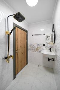 Łazienka z umywalką i drewnianymi drzwiami w obiekcie Къщата w mieście Isperikh