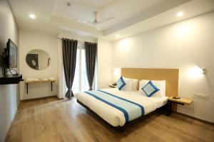 a hotel room with a bed and a mirror at Hotel Rudratesh in New Delhi