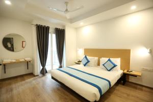 a bedroom with a large bed with blue pillows at Hotel Rudratesh in New Delhi