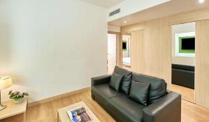 uma sala de estar com um sofá de couro preto em NH Campo Cartagena em Cartagena